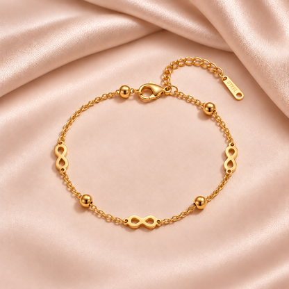 Bracelet infini doré sur satin beige rosé